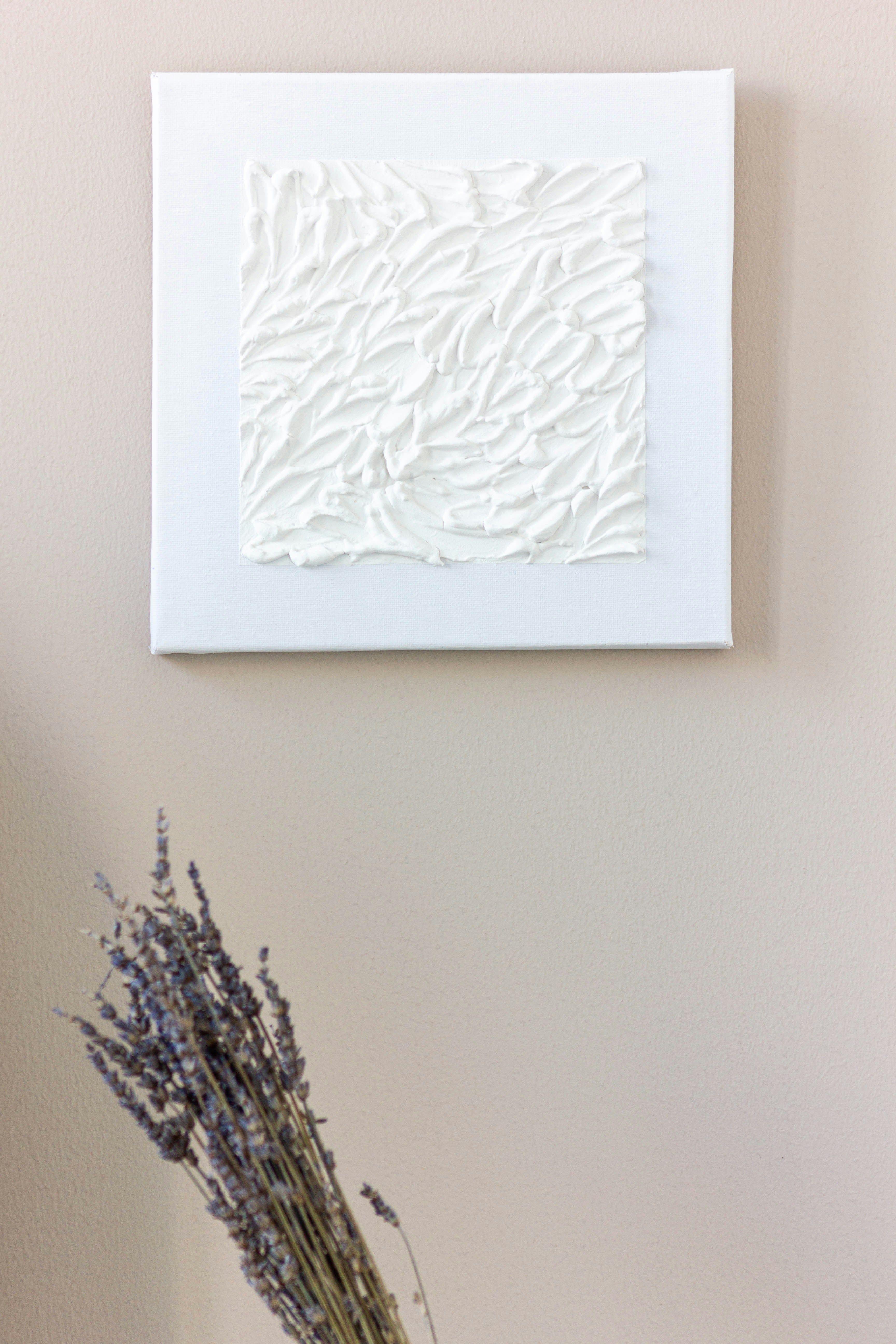 a vase with some flowers in it next to a picture