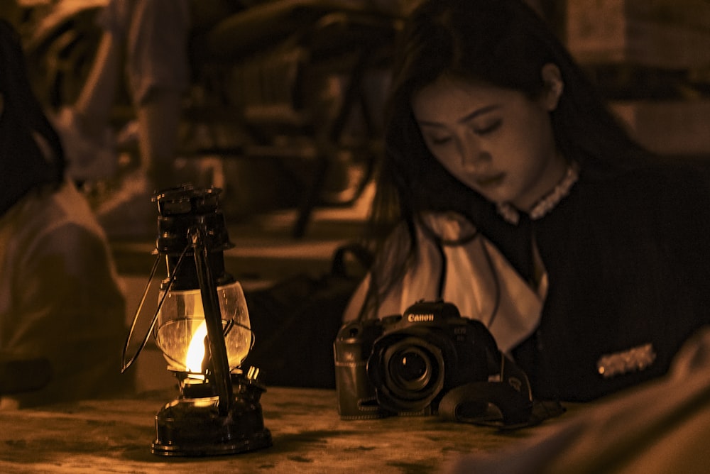 a woman sitting at a table with a camera