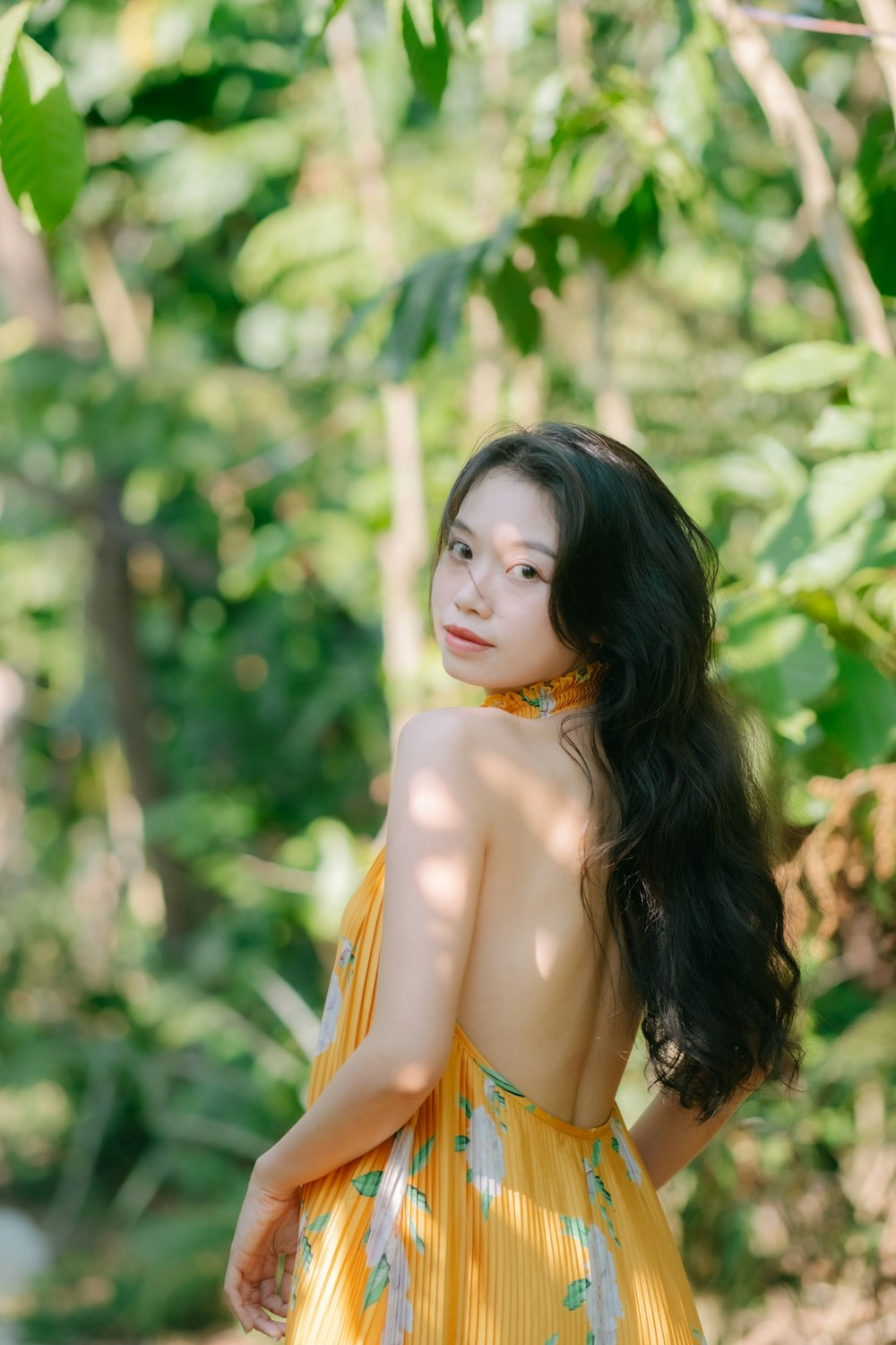 a woman in a yellow dress posing for a picture