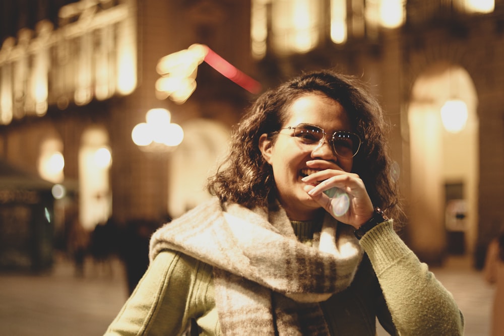 a woman talking on a cell phone while wearing a scarf