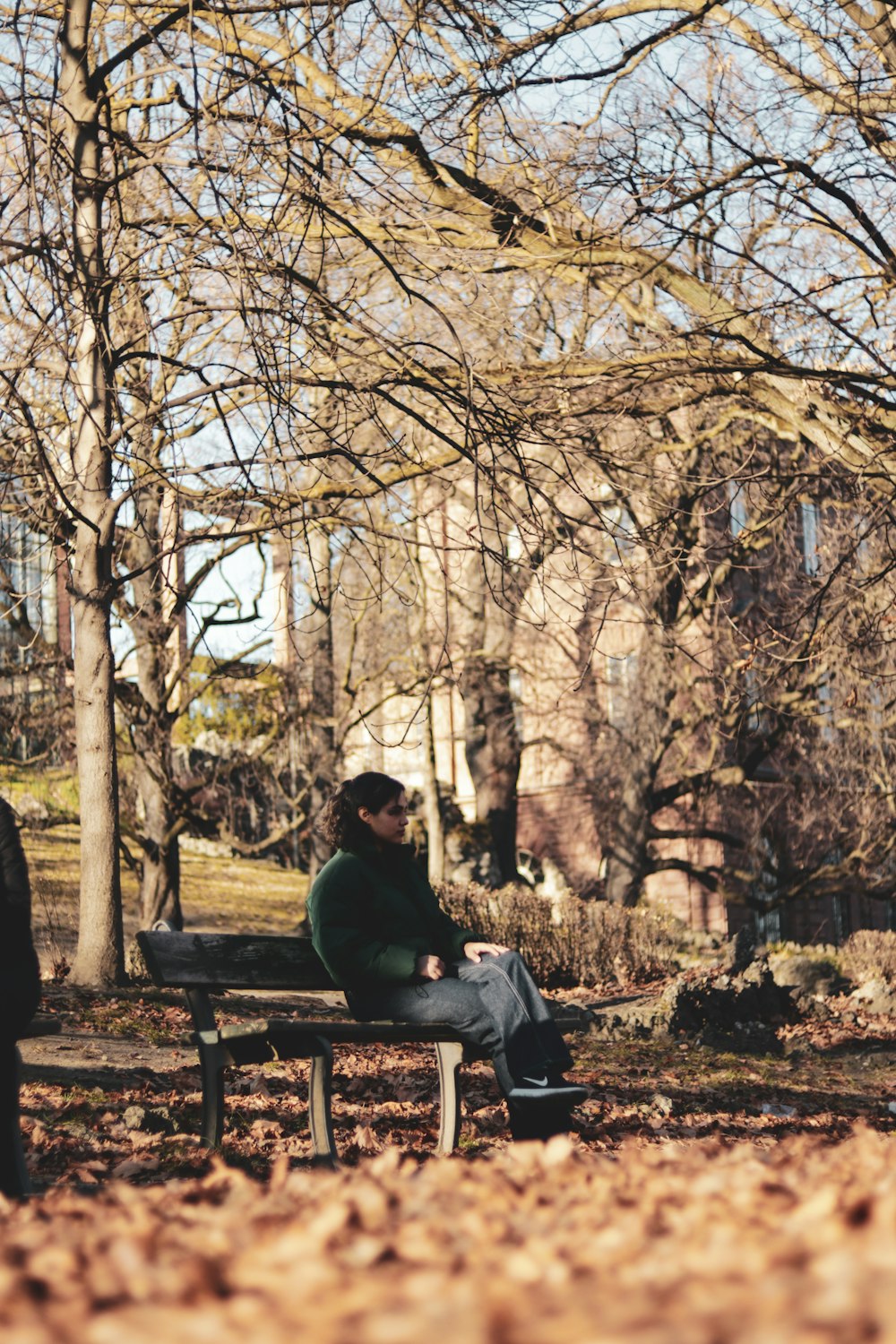 a person sitting on a bench in a park