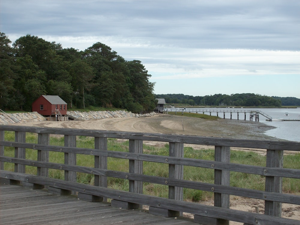 a wooden bridge with a red house in the background