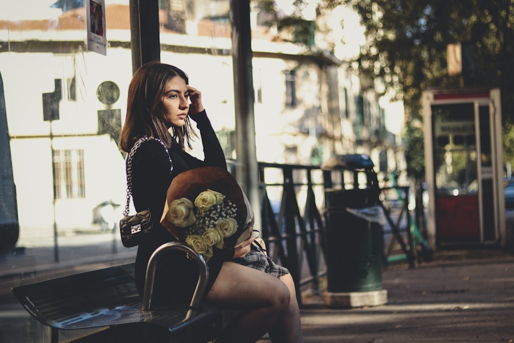 a woman sitting on a bench talking on a cell phone