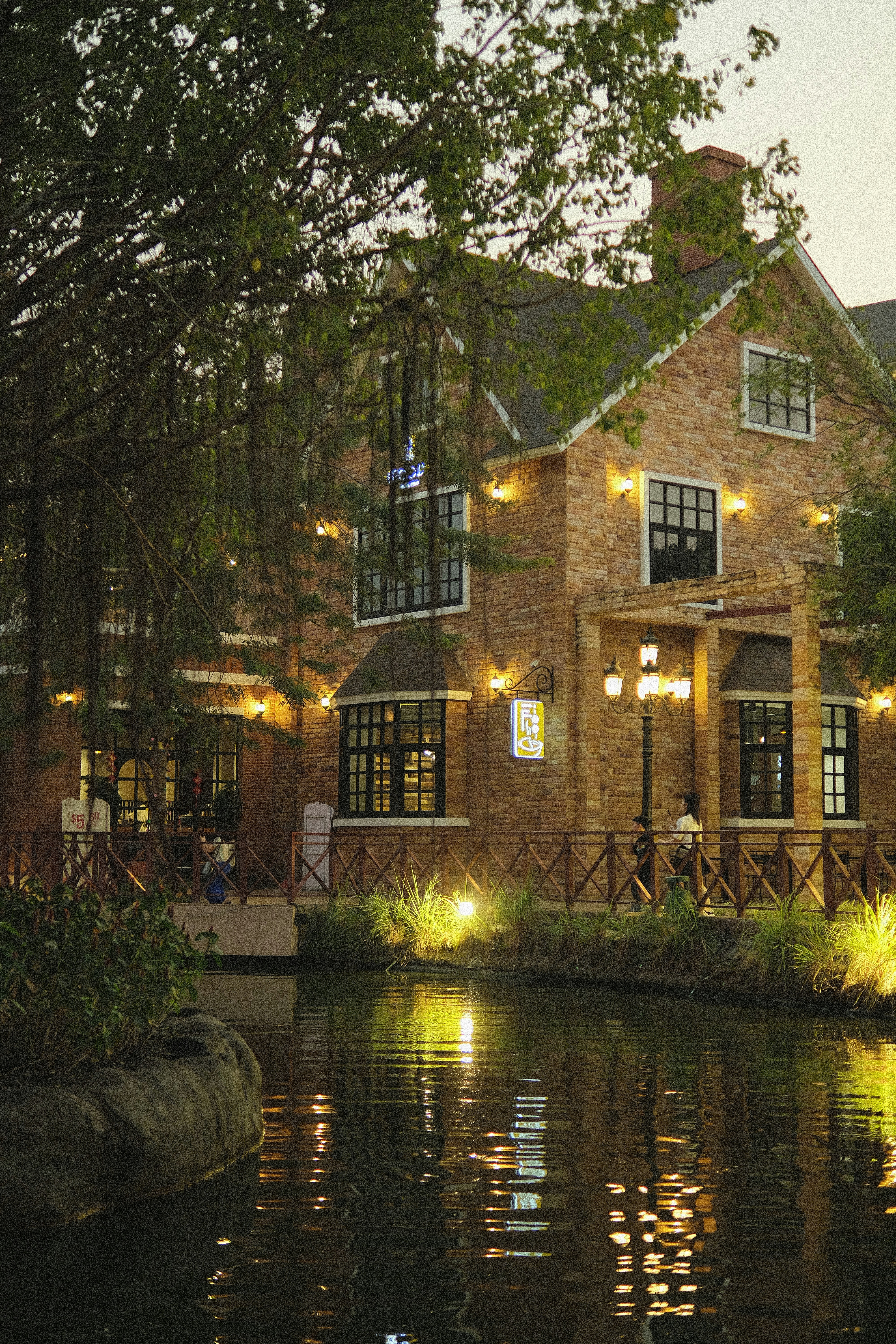 a large brick house with a pond in front of it
