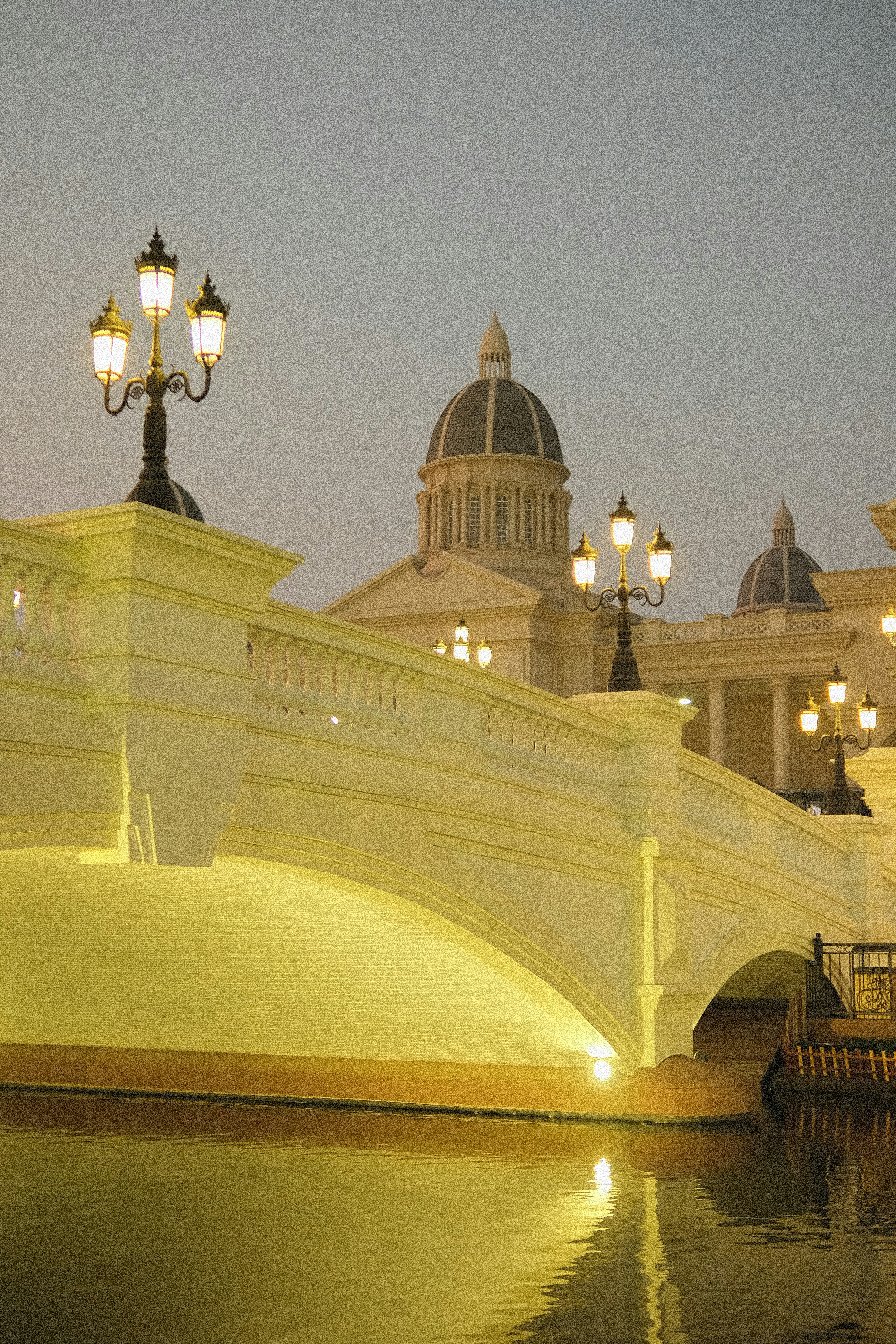 a bridge over a body of water with a building in the background