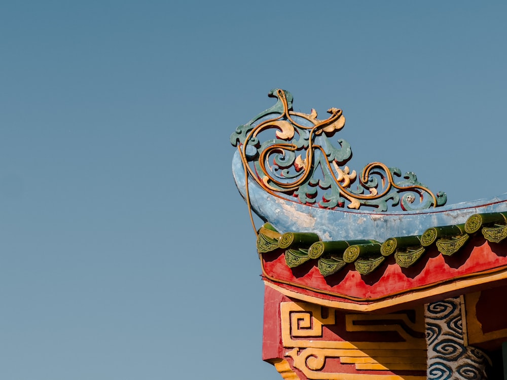 a decorative roof with a blue sky in the background