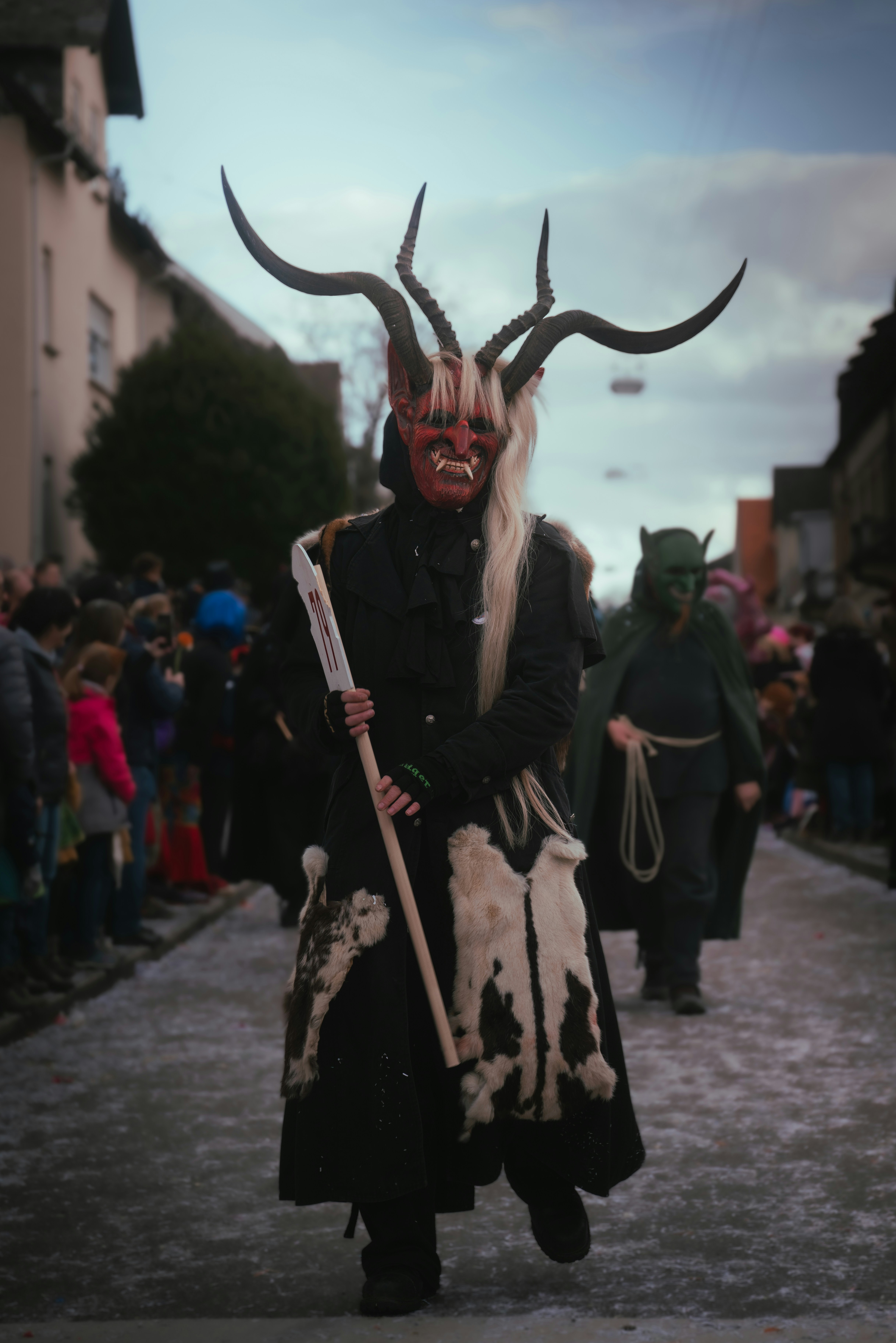 a man in a horned costume is walking down the street