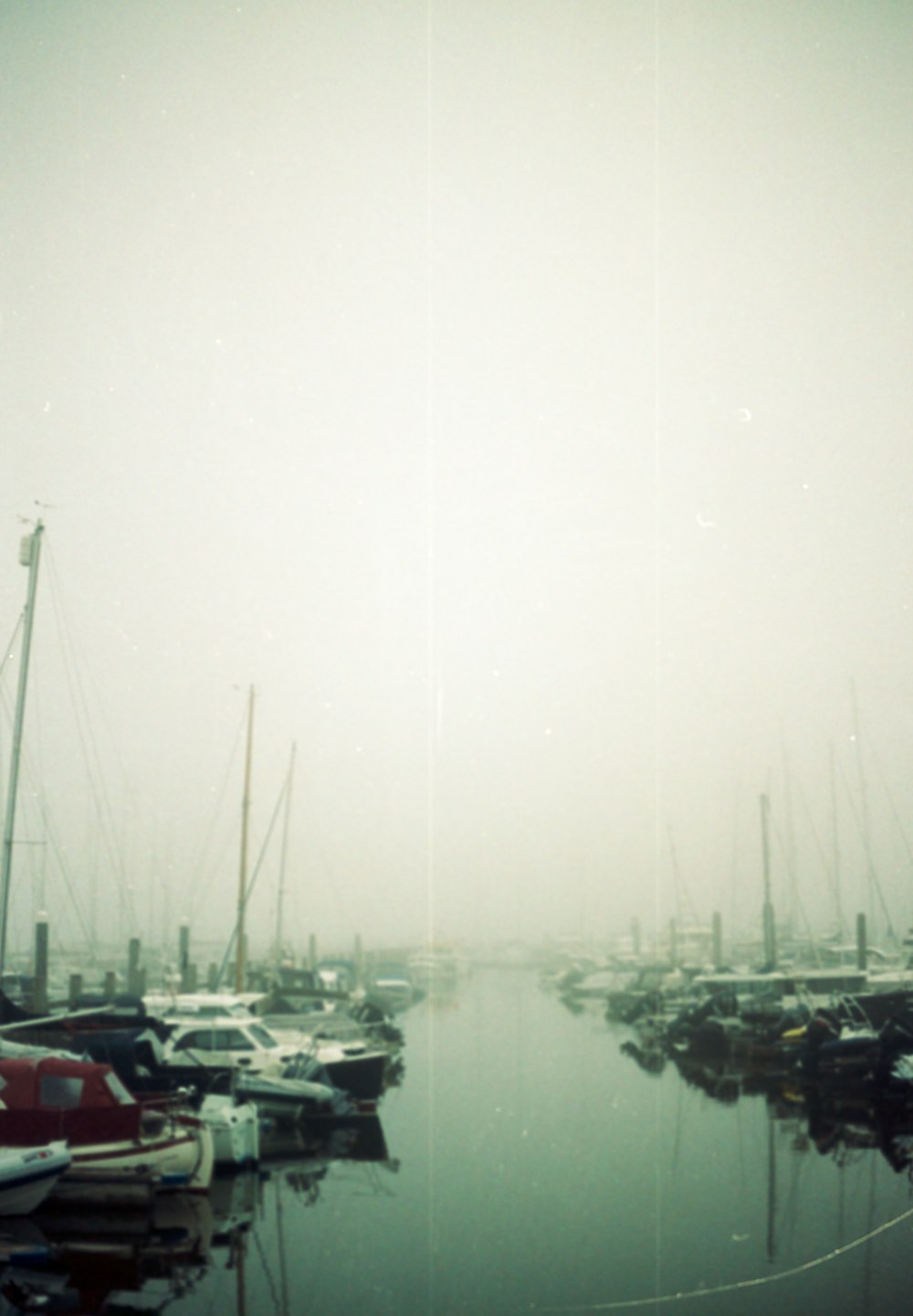 a harbor filled with lots of boats on a foggy day