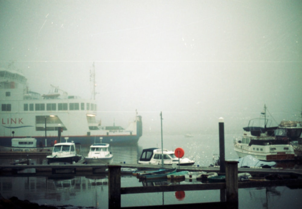 several boats docked in a harbor on a foggy day