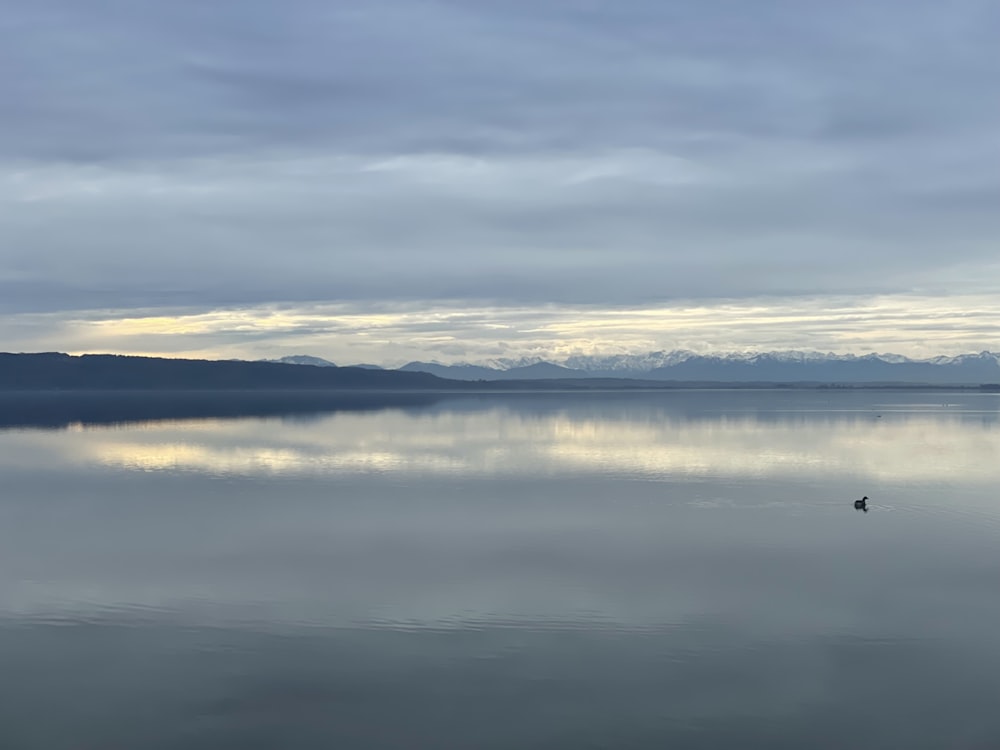 a large body of water with mountains in the background