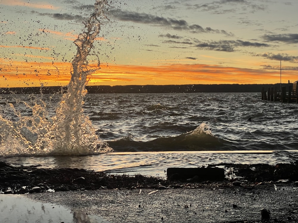 a large body of water with a sunset in the background