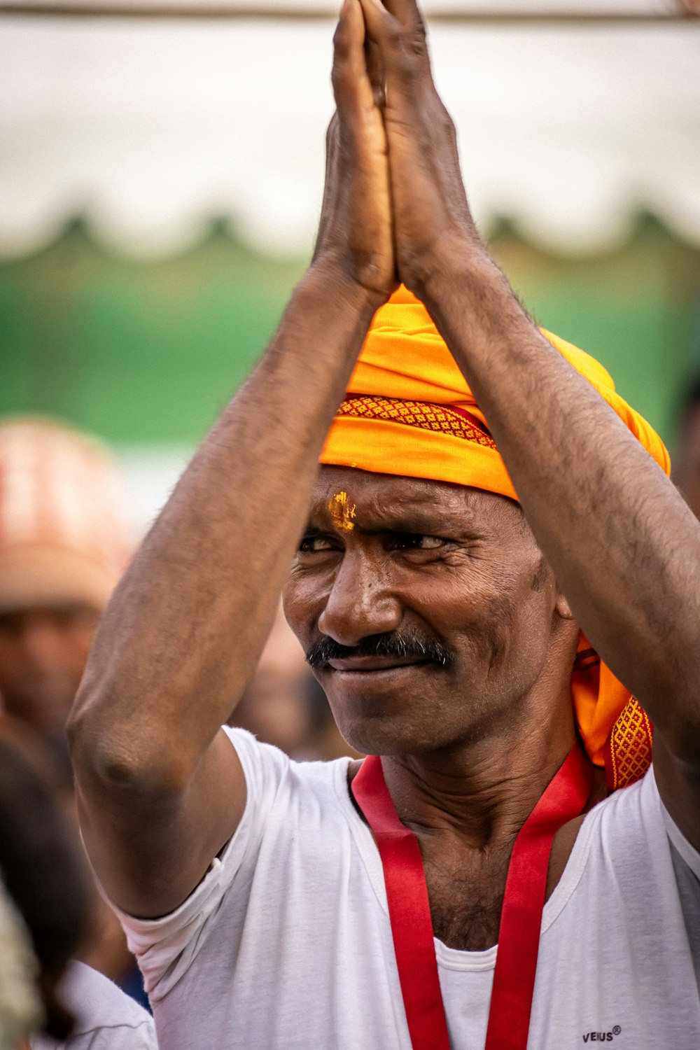 a man wearing a yellow turban and holding his hands up