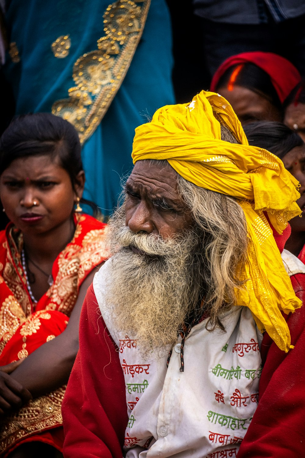 a man with a yellow turban sits in front of other people