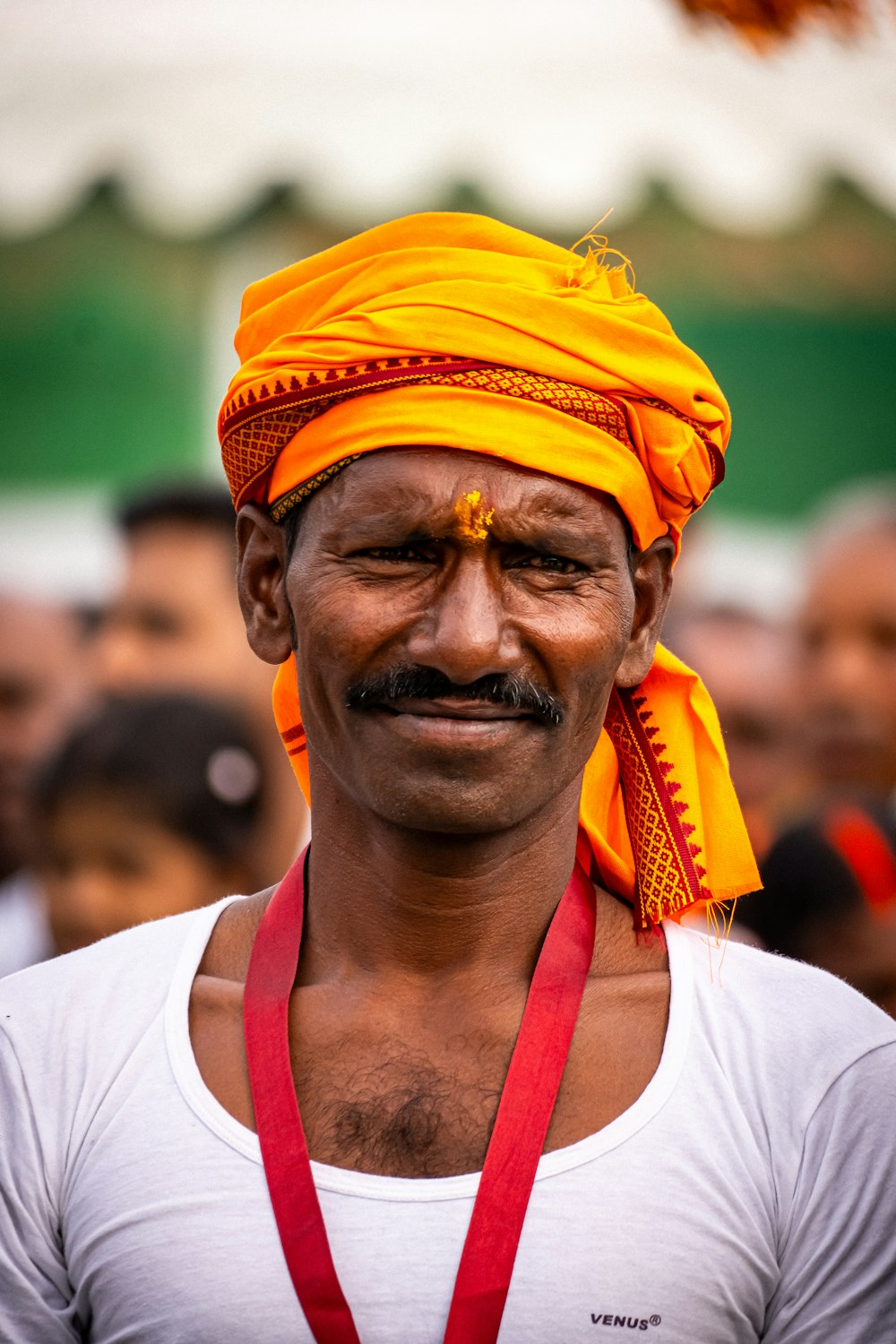 a man wearing a yellow turban and a red lanyard