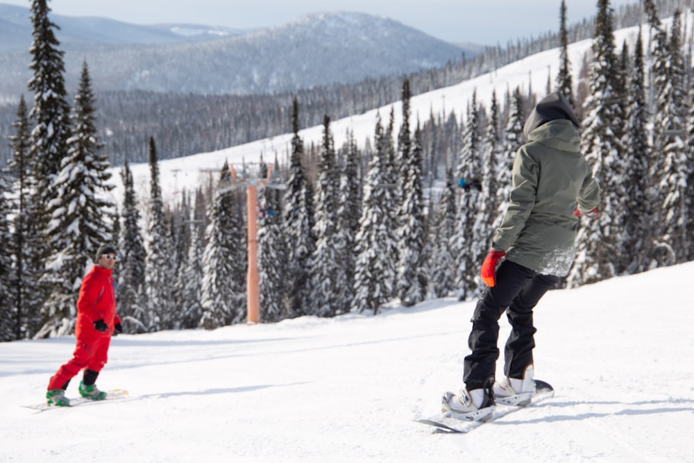 a man riding a snowboard down a snow covered slope