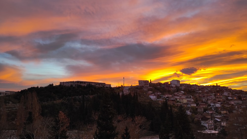 a sunset view of a city from a hill