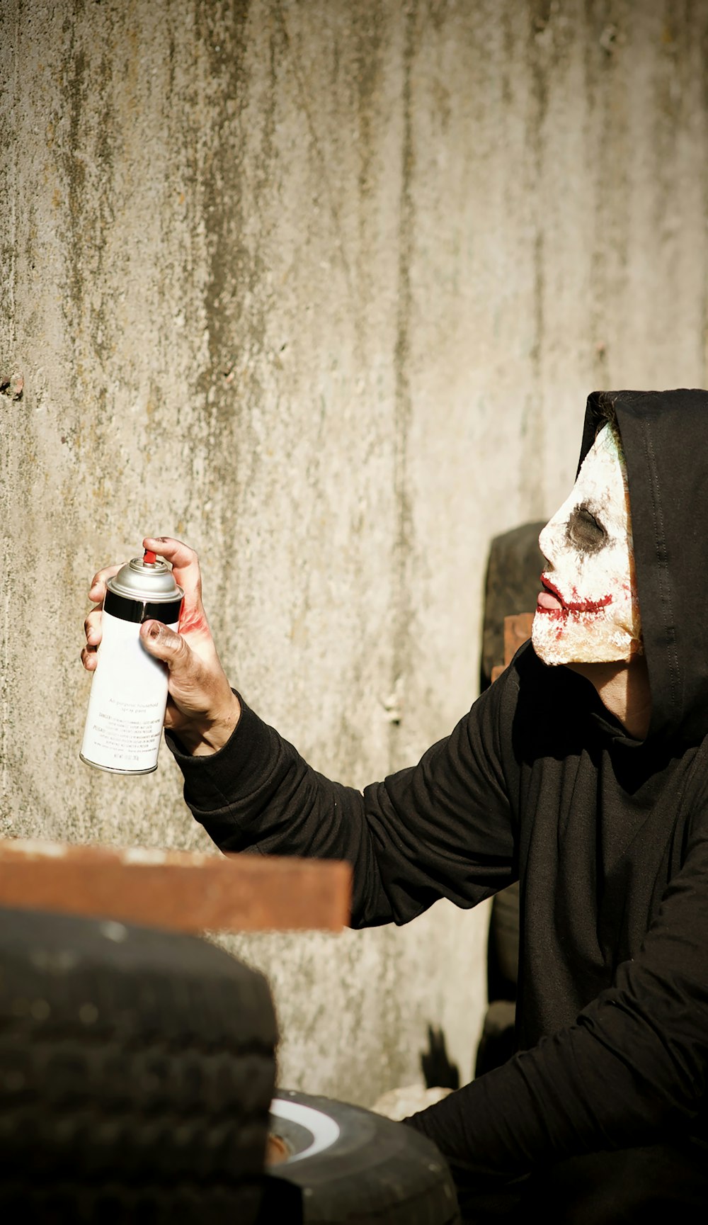 un uomo con una maschera che tiene in mano una lattina di birra