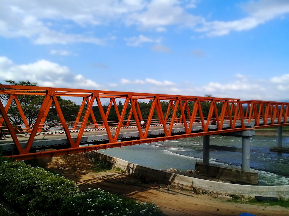 a red bridge over a body of water