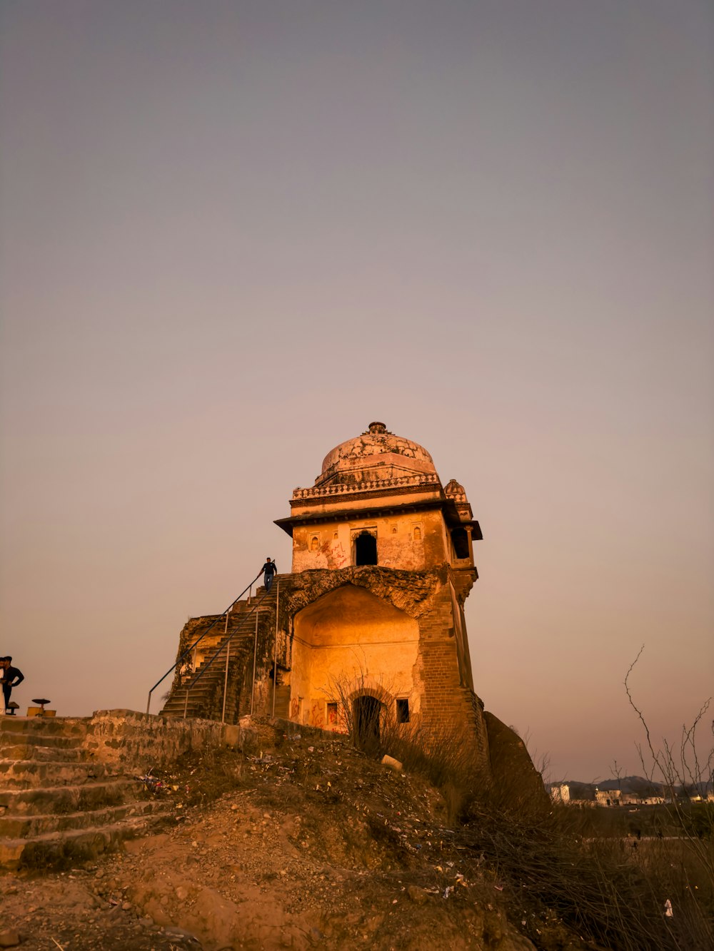 an old building on a hill with stairs leading up to it