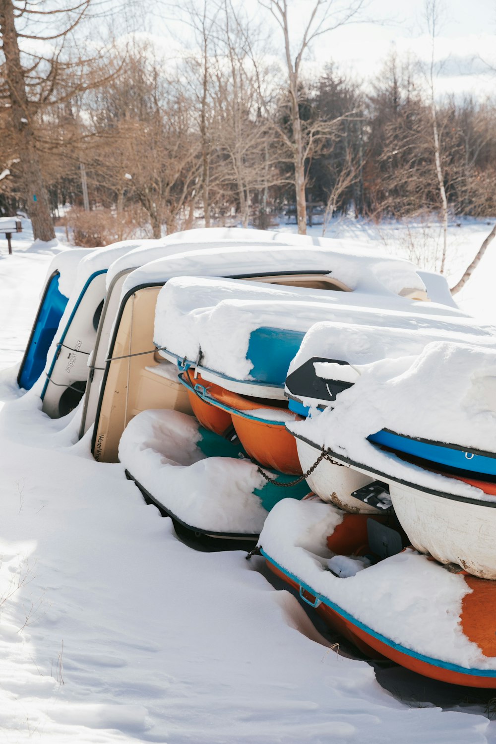 a row of snow covered boats sitting in the snow