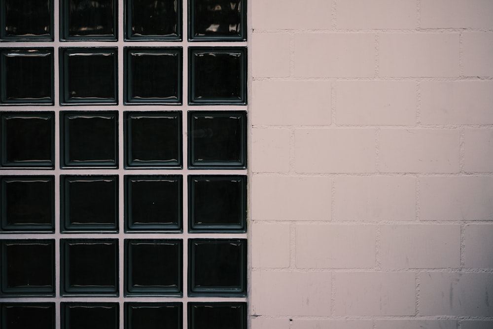 a white brick wall with black glass blocks