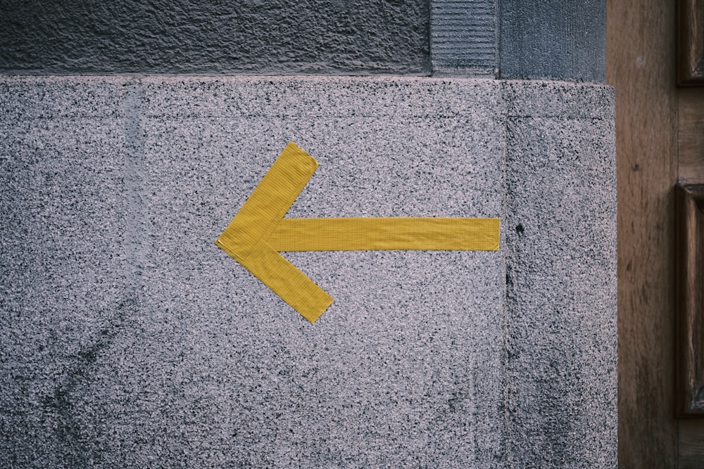 a yellow arrow painted on the side of a building