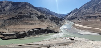 a river running through a valley surrounded by mountains