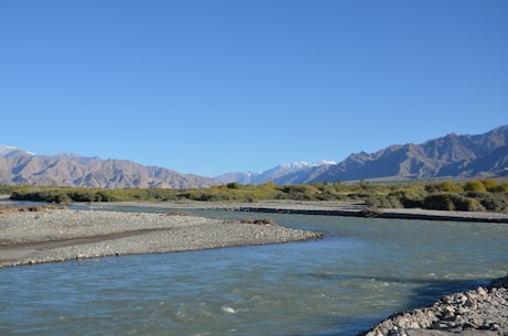 a river with mountains in the background