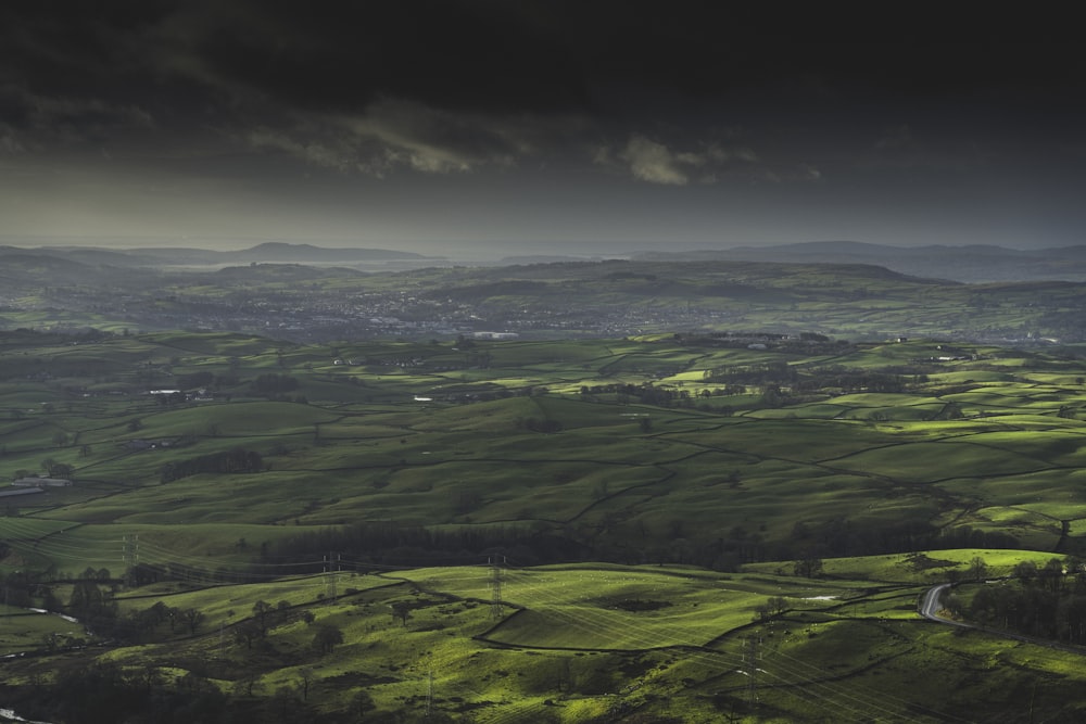 a view of a lush green valley under a cloudy sky