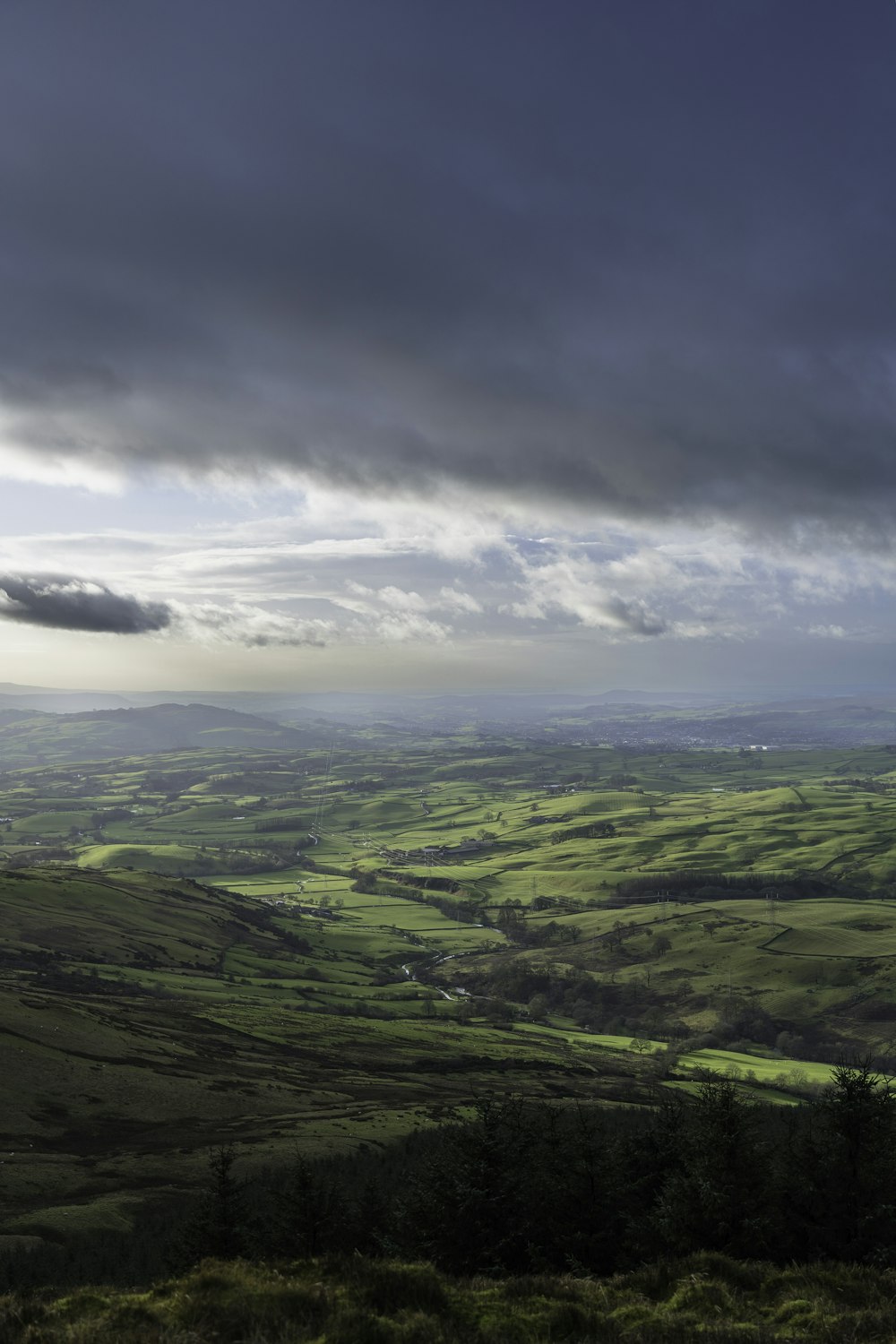 a view of a lush green valley under a cloudy sky