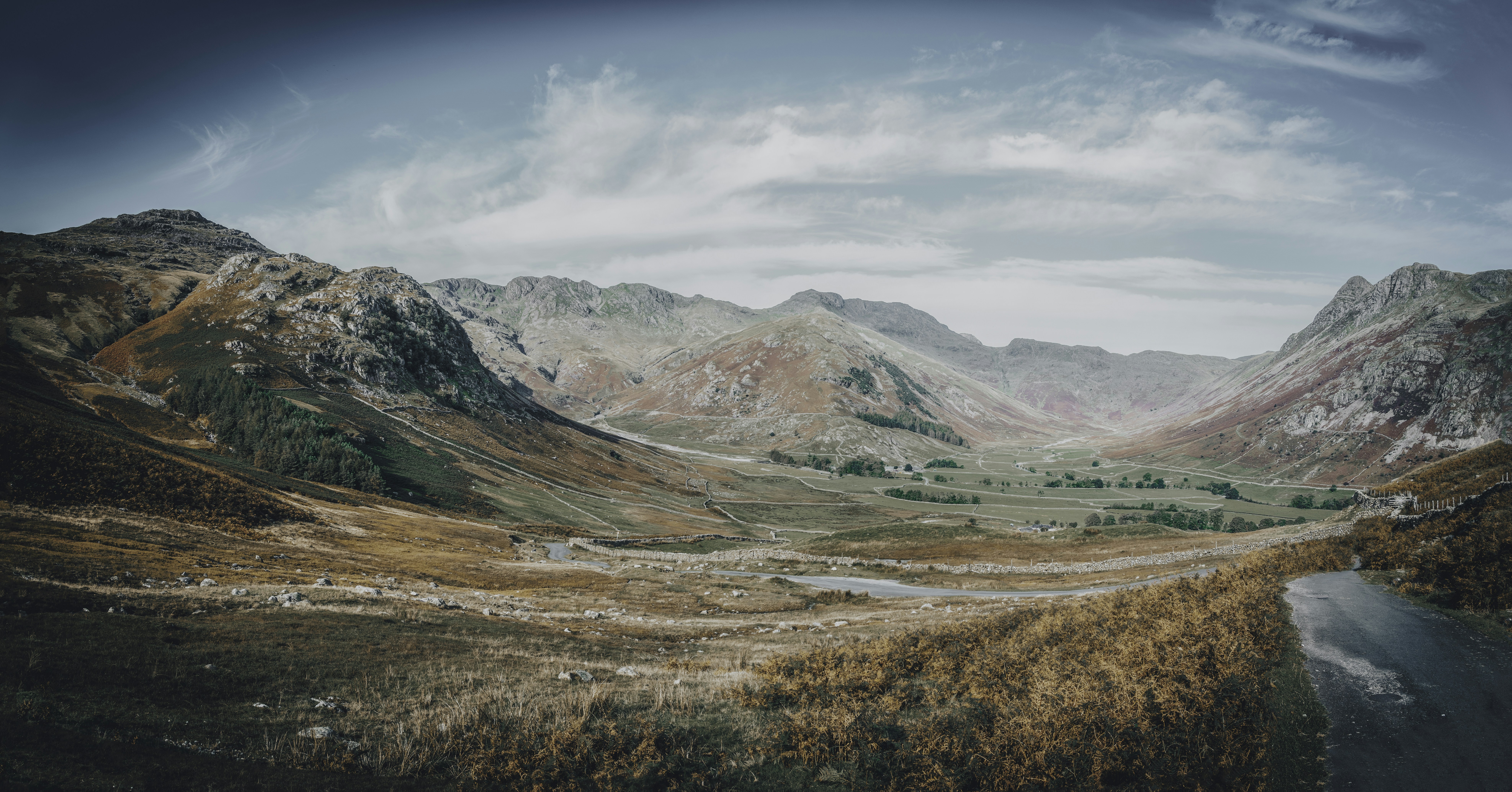 a scenic view of a valley with mountains in the background