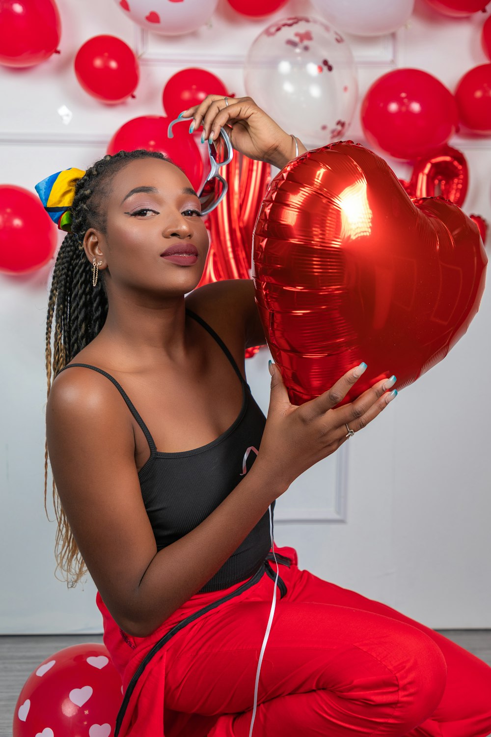 a woman holding a red heart shaped balloon