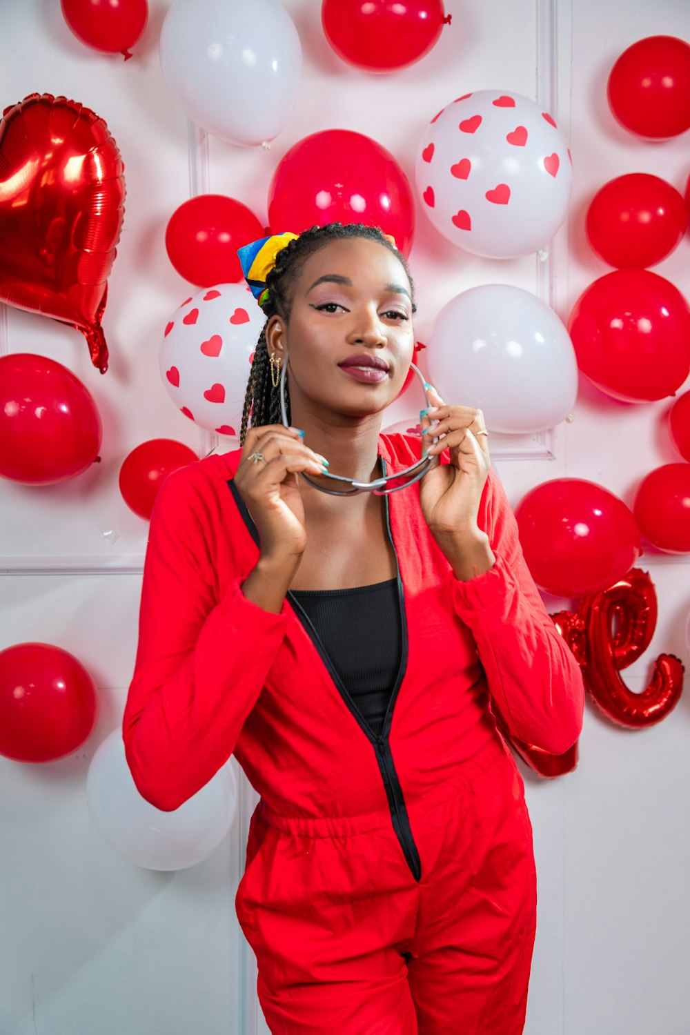 a woman in a red suit holding a balloon