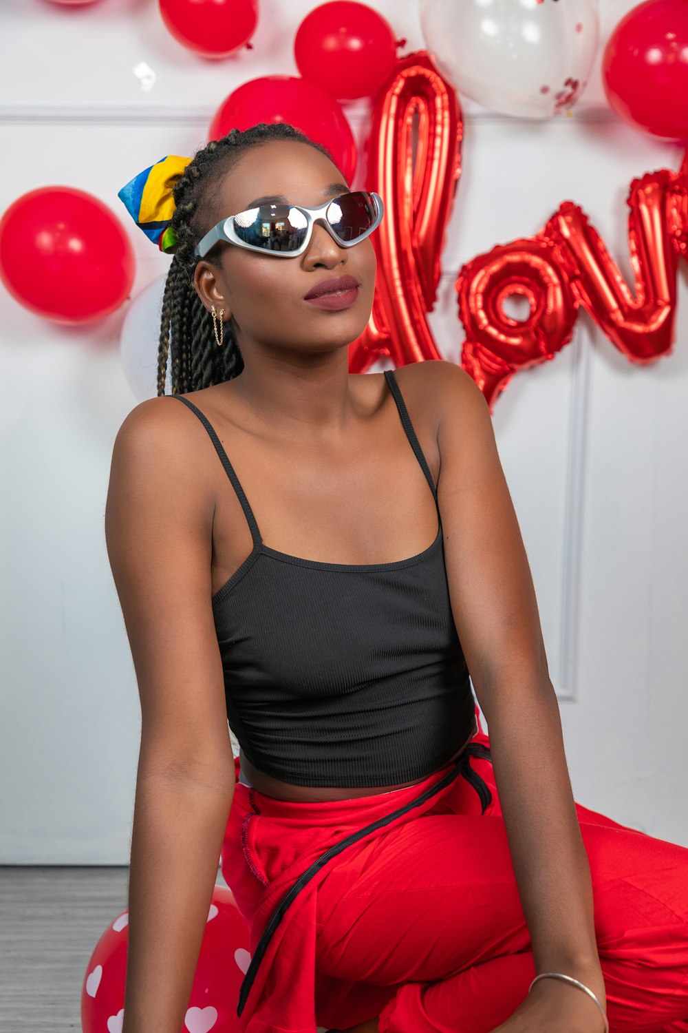 a woman sitting on the floor wearing sunglasses