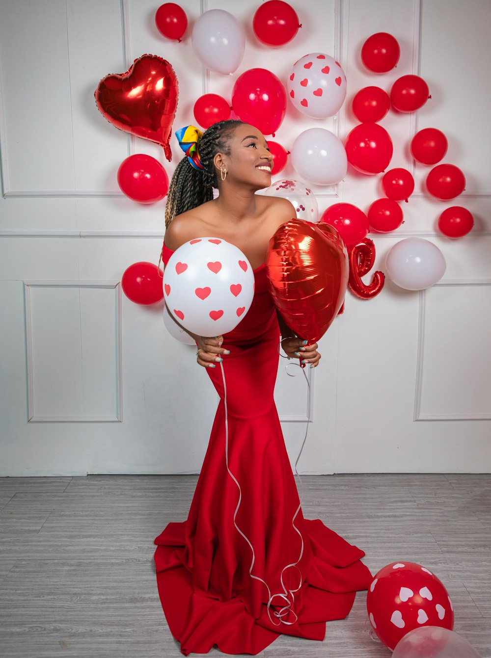 a woman in a red dress holding balloons