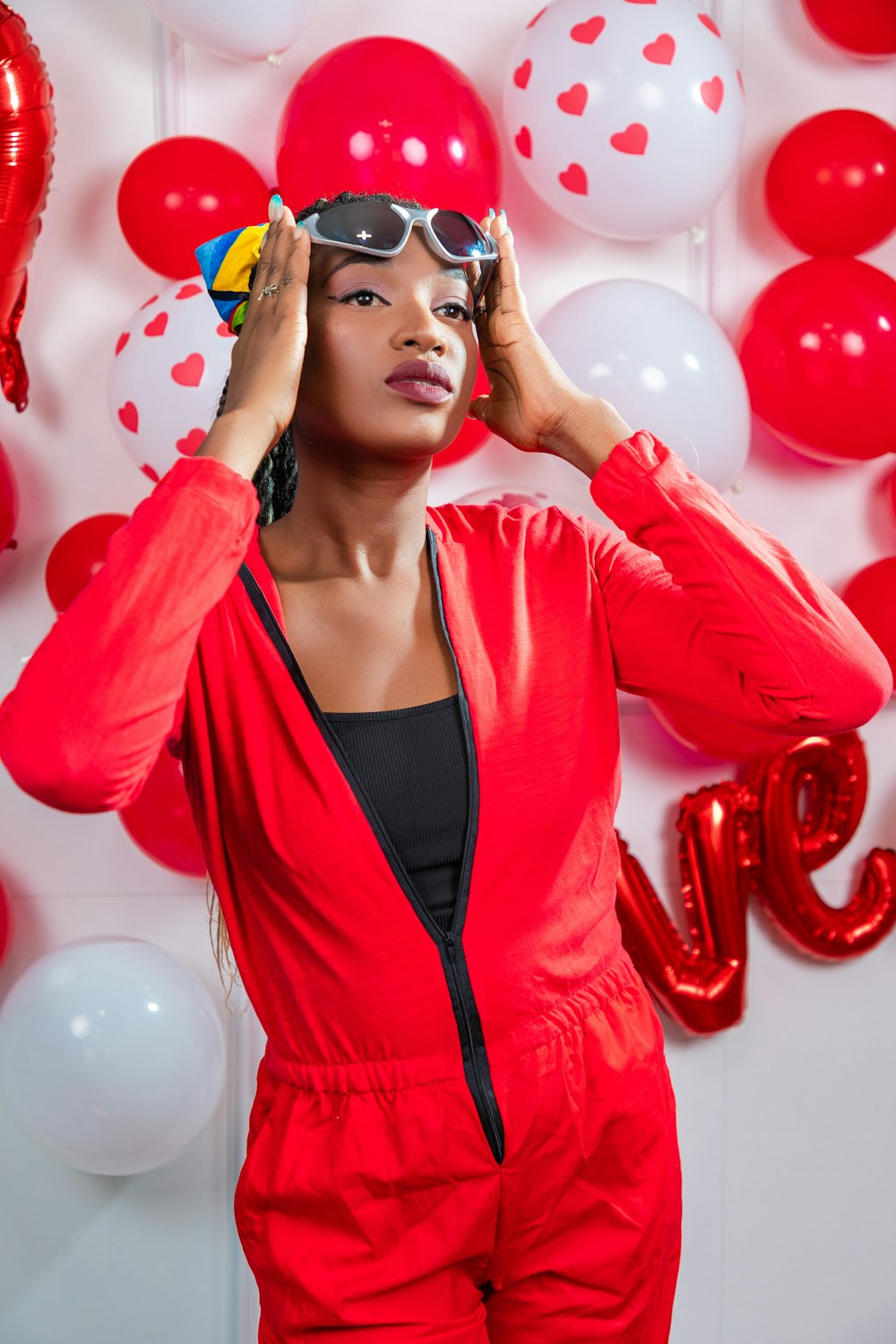 a woman in a red jumpsuit and sunglasses