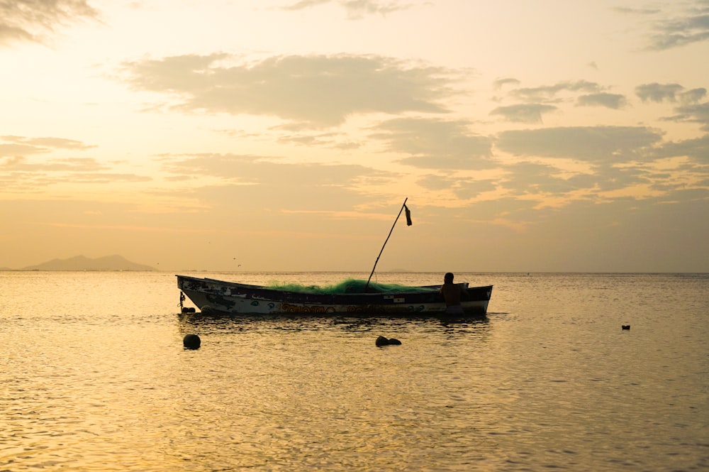 a small boat floating on top of a large body of water