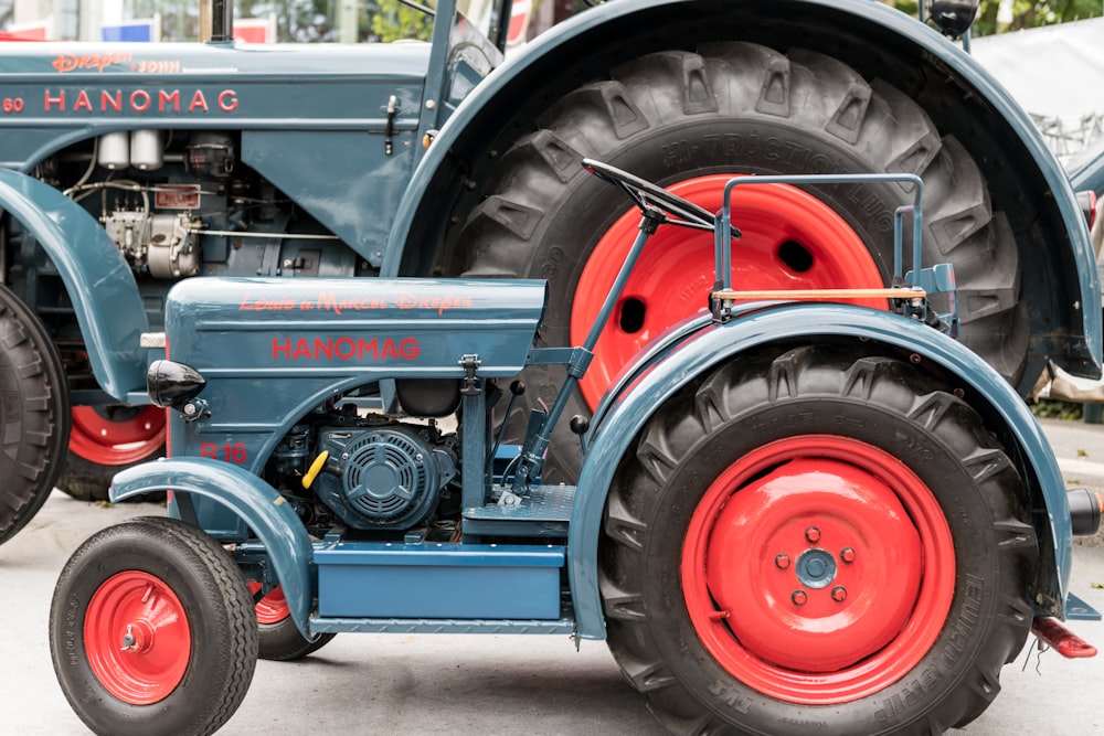 a blue and red tractor sitting on top of a parking lot