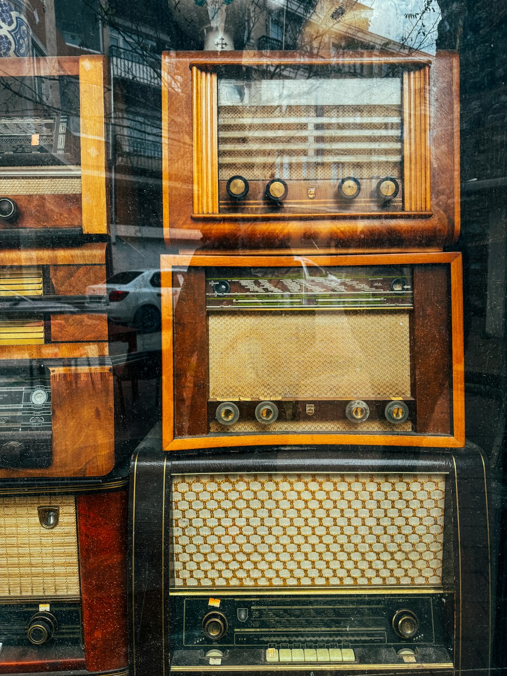 a bunch of old radio's sitting in a window