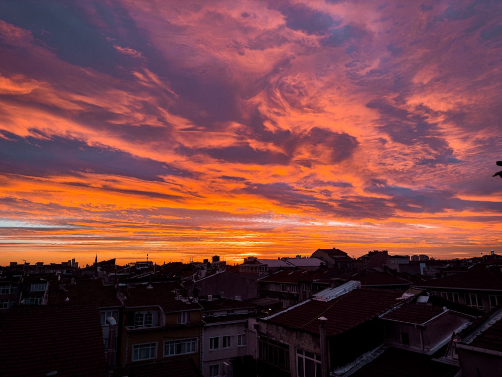 a view of a sunset over a city from a rooftop