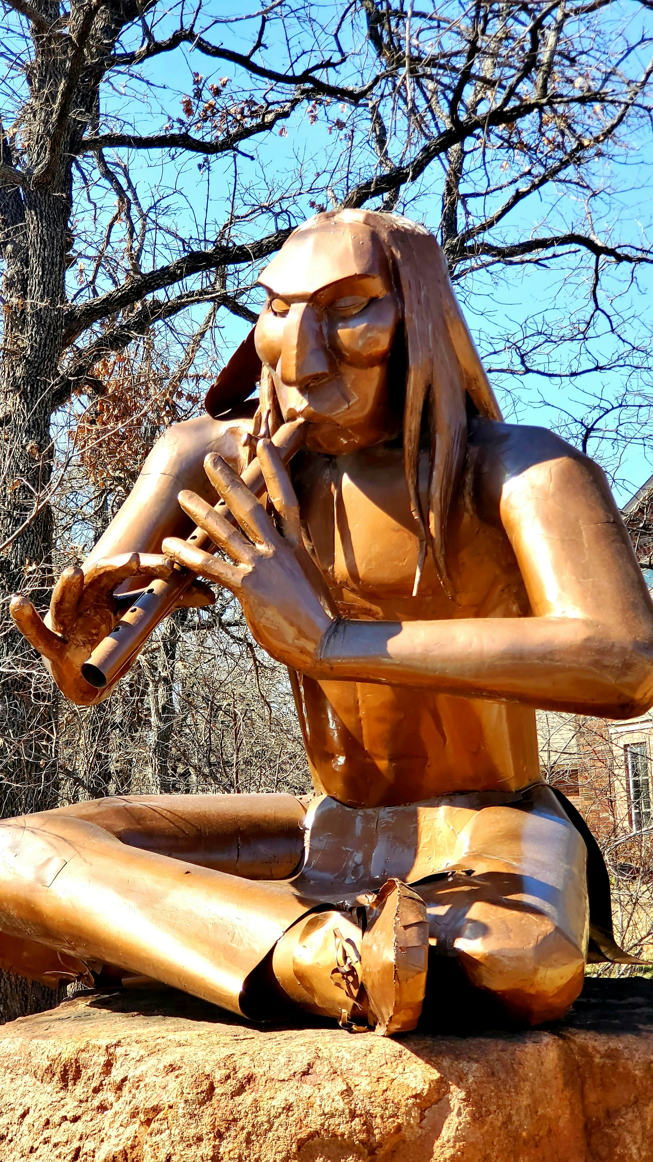 a statue of a woman sitting on top of a rock