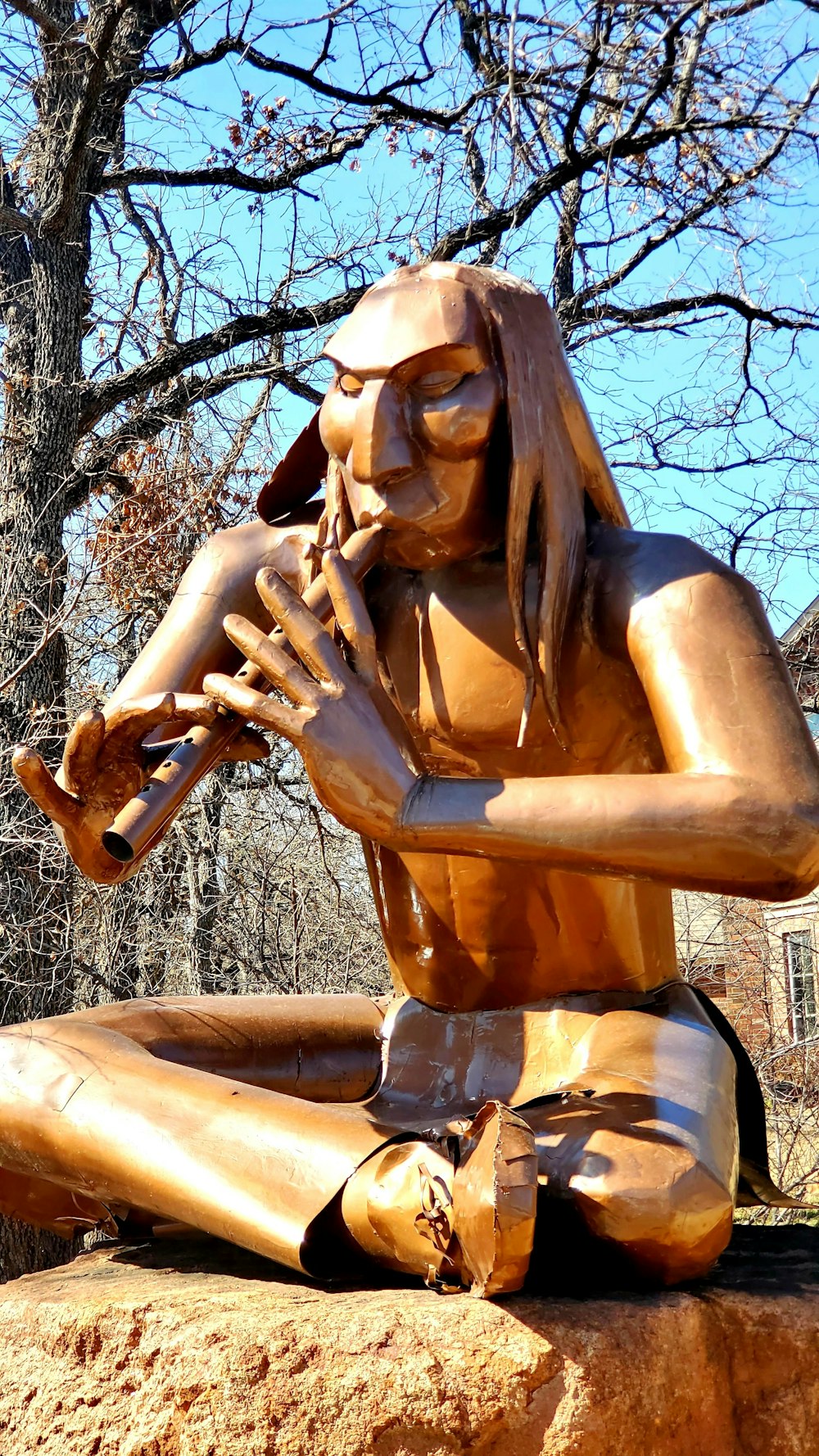 a statue of a woman sitting on top of a rock