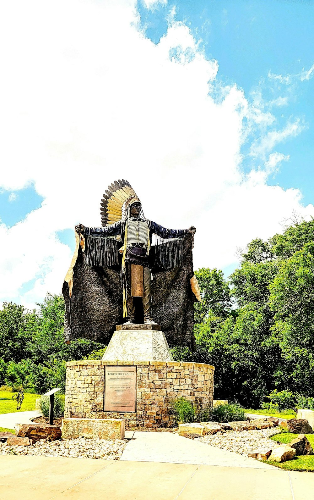 a statue of a native american standing on a rock