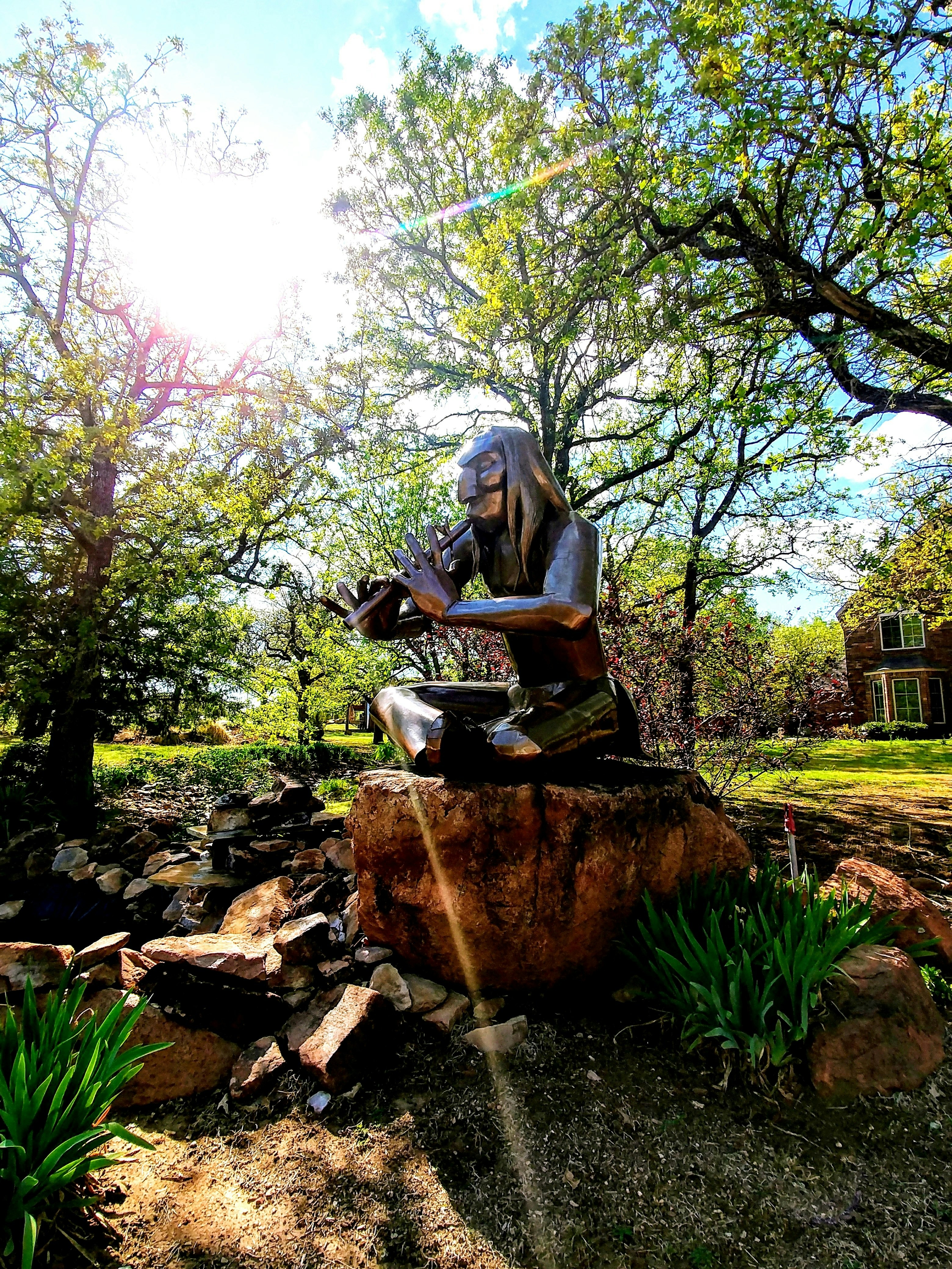 a statue of a woman sitting on top of a rock