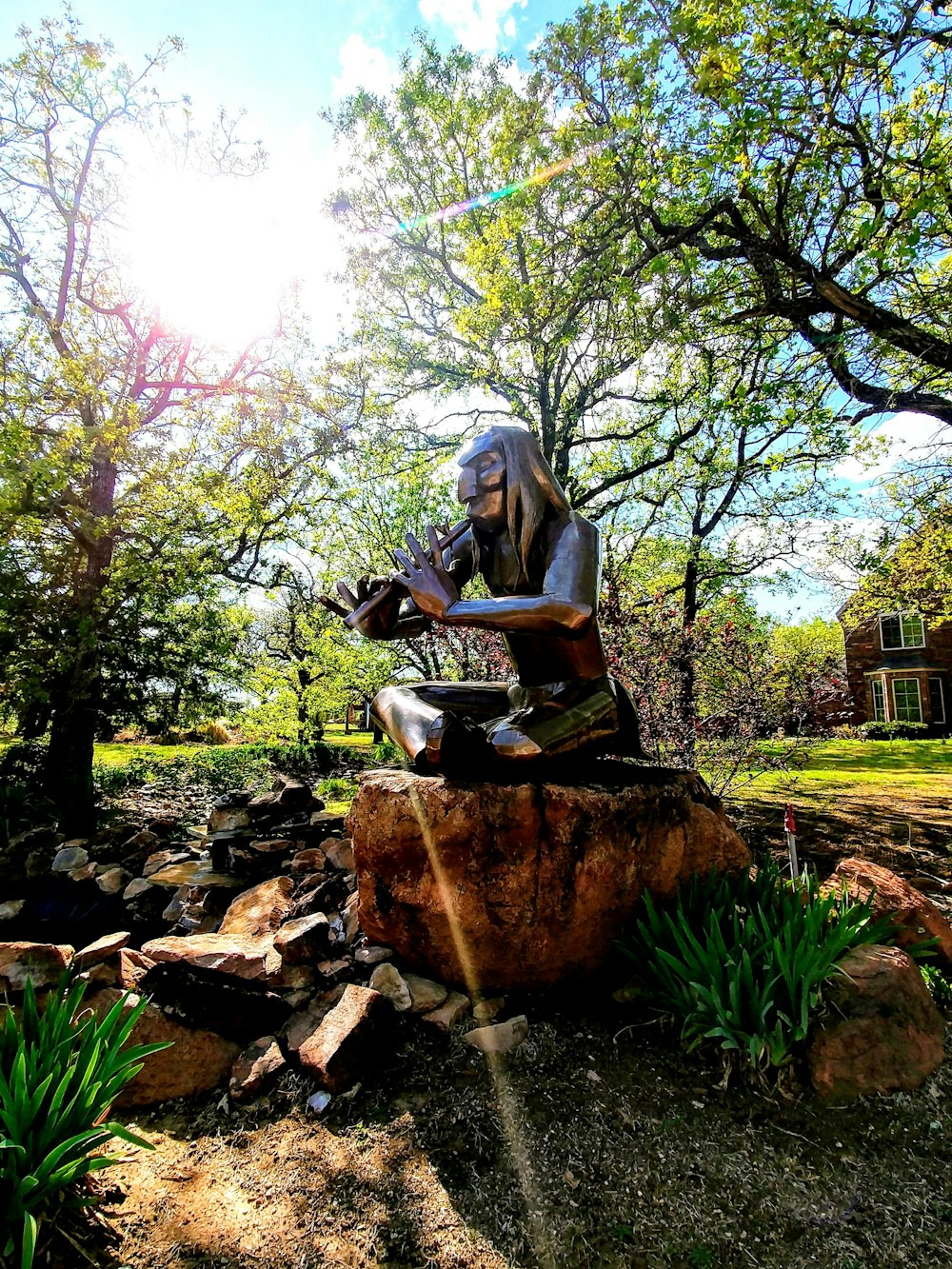 a statue of a woman sitting on top of a rock