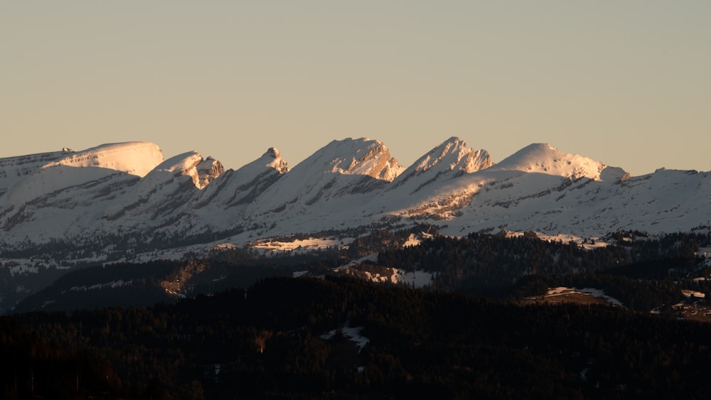 a mountain range with snow covered mountains in the background