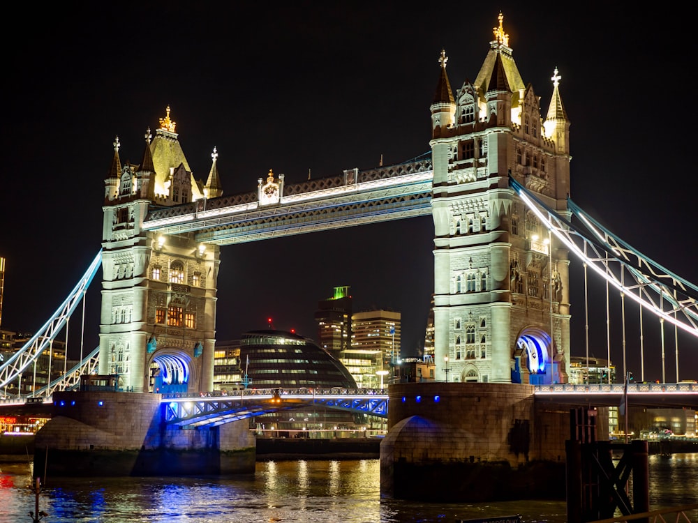 the tower bridge is lit up at night