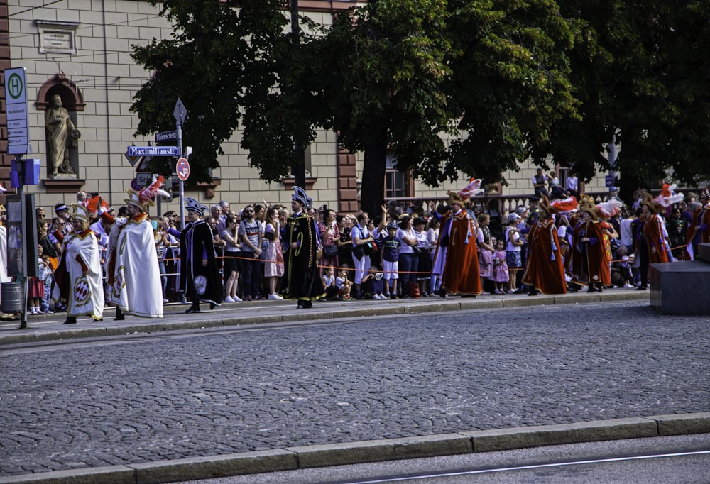 a group of people standing on the side of a road