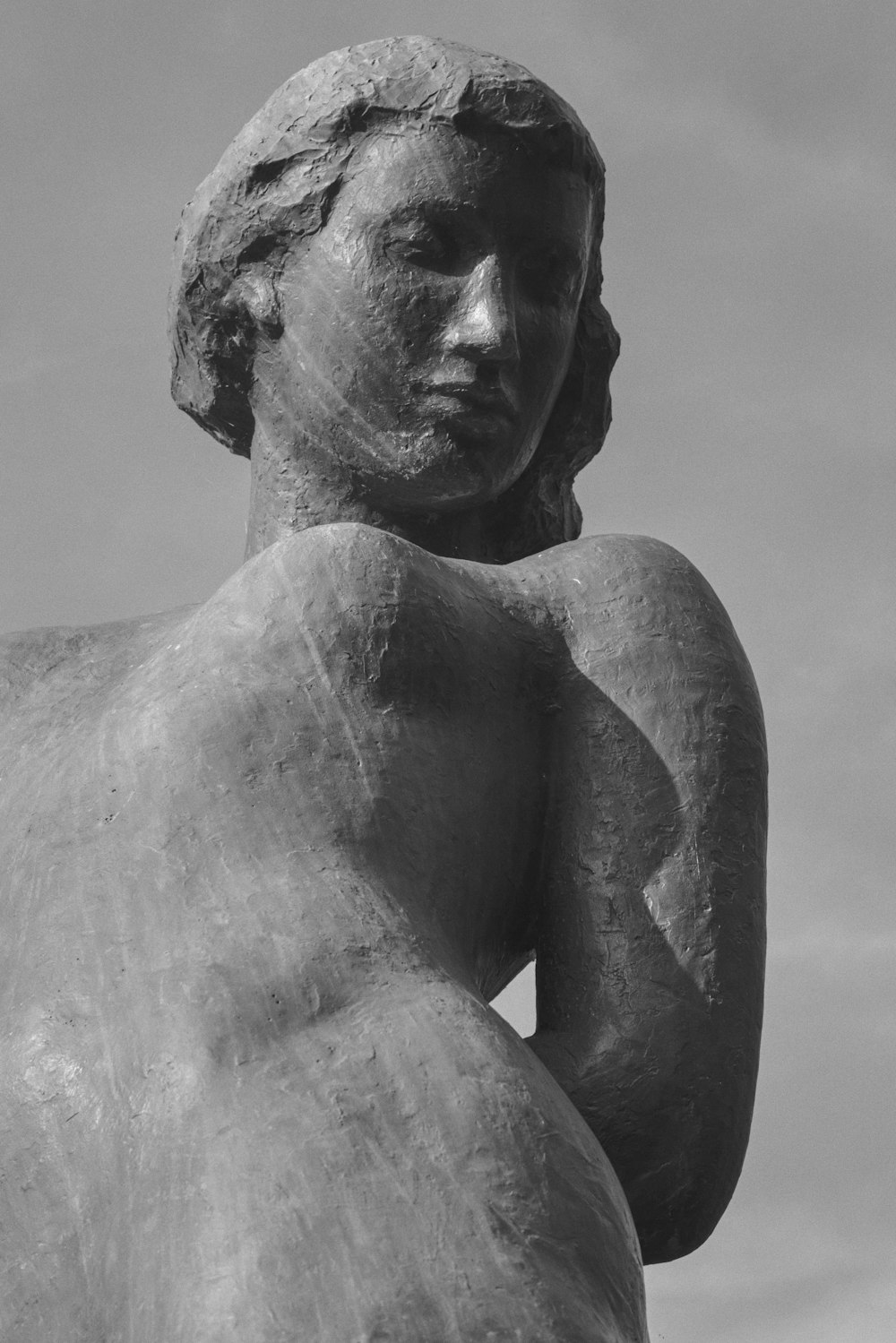 a black and white photo of a statue of a woman