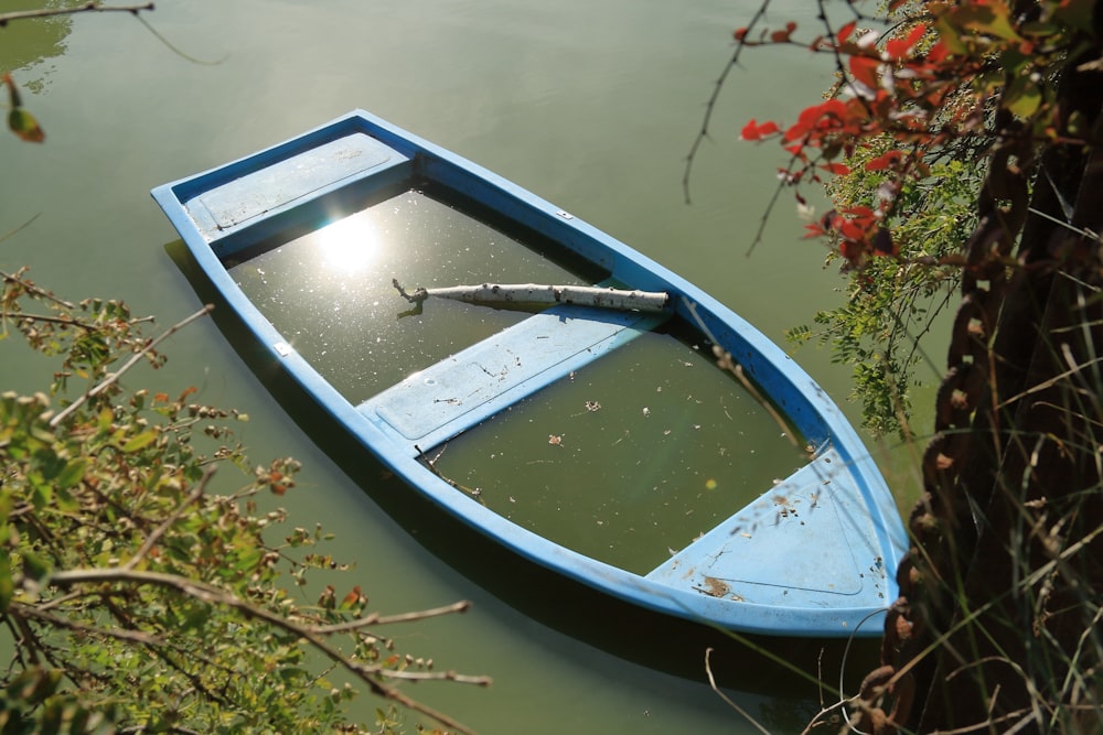 a small blue boat floating on top of a lake